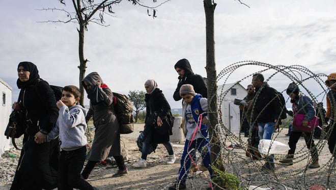 Migrants and refugees cross the Greek-Macedonian border near Gevgelija on November 15, 2015.