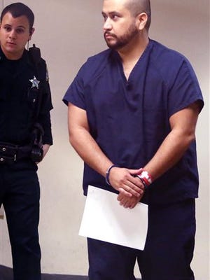 In this Jan. 10, photo, George Zimmerman, right, walks in handcuffs during a first appearance at the Seminole County Courthouse in Sanford, Fla. Zimmerman was charged with aggravated assault with a weapon in an incident where he allegedly threw a wine bottle.