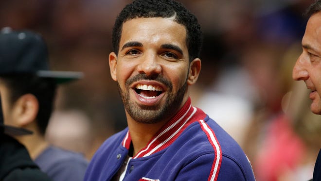 Drake, the Sunday headliner at Coachella, smiles as he sits courtside at Staples Center during the Clippers-Warriors game on March 31.