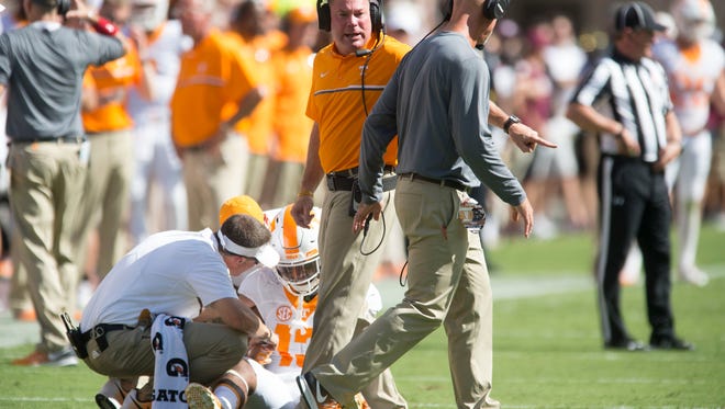Tennessee head coach Butch Jones talks with Tennessee defensive backs coach Willie Martinez while  defensive back Malik Foreman (13) is tended too during the first half of the game against Texas A&M on Saturday, October 8, 2016. (SAUL YOUNG/NEWS SENTINEL) 