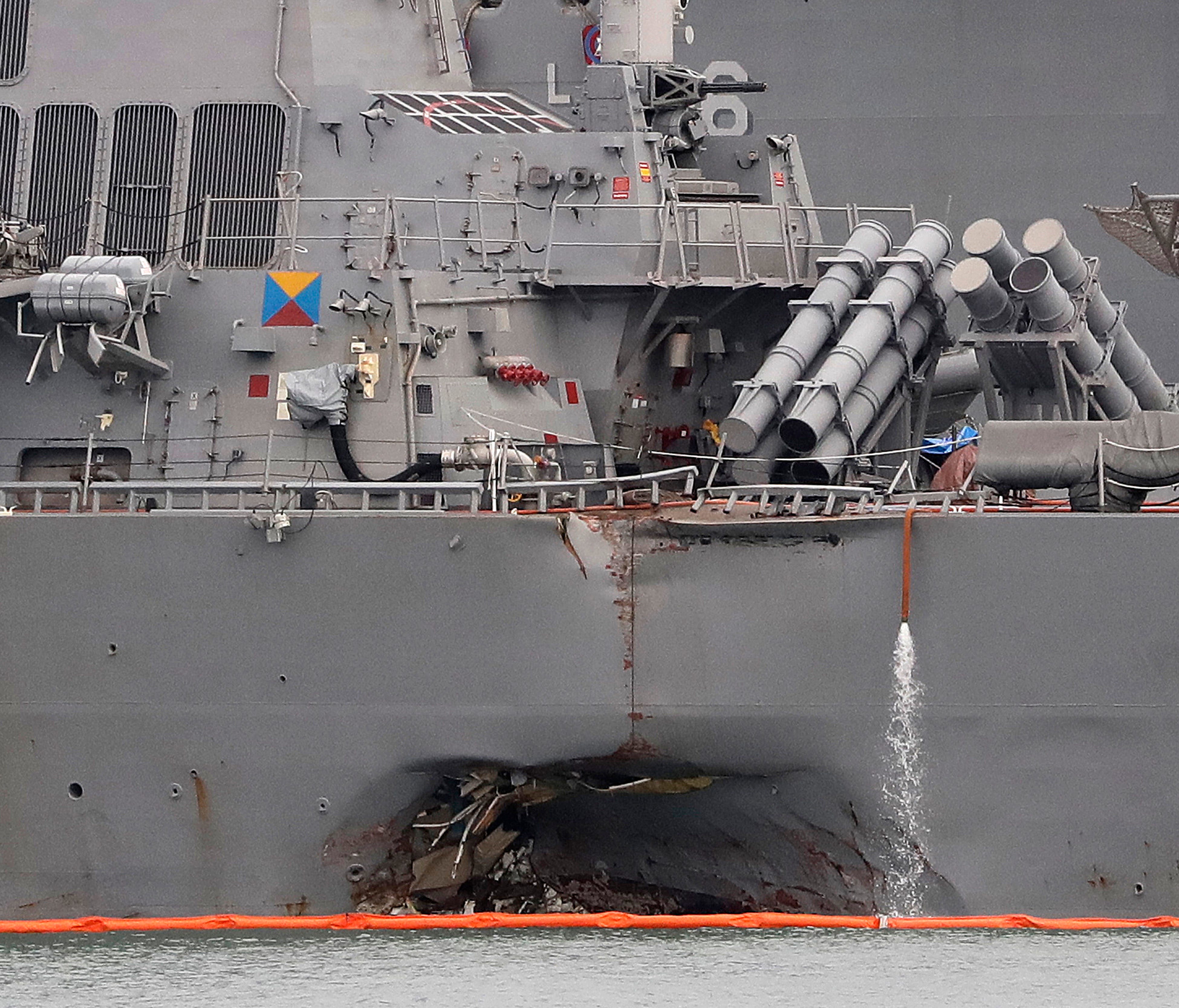 The damaged port aft hull of USS John S. McCain, is seen while docked at Singapore's Changi naval base on  Aug. 22, 2017 in Singapore. The focus of the search for 10 U.S. sailors missing after a collision between the USS John S. McCain and an oil tan