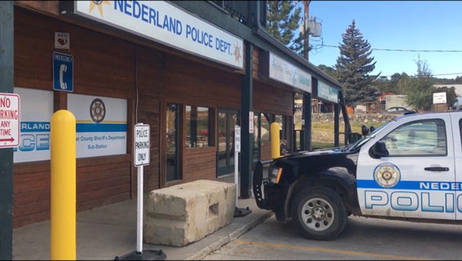 FILE - This Oct. 13, 2016, file photo shows the exterior of the police station in the town of Nederland, Colo. A man accused of leaving a bomb outside the police station in the small mountain town to avenge the killing of a fellow member of a hippie group in the 1970s is expected to plead guilty. David Michael Ansberry is expected to acknowledge Tuesday, July 18, 201, that he left a powerful bomb containing arsenic outside the Nederland Police Department on Oct. 11. (AP Photo/Sadie Gurman, File)