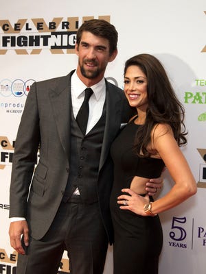 Michael Phelps, the most decorated Olympian of all time arrive on the red carpet with his wife Nicole Phelps for Celebrity Fight Night on Mar. 18, 2017 at JW Marriott Desert Ridge Resort & Spa in Phoenix, Ariz.