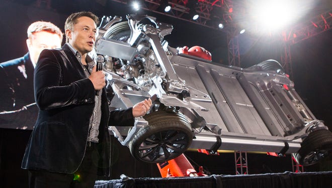 Elon Musk, CEO of Tesla Motors Inc., announces its new Tesla "D", a new all-wheel-drive version of the Tesla Model S car in Hawthorne, Calif. in 2014. The company is acquiring a Grand Rapids-based auto supplier.