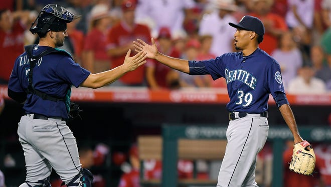 Seattle Mariners catcher Mike Zunino, left, and relief pitcher Edwin Diaz congratulate each other after the Mariners defeated the Los Angeles Angels 3-2 in a baseball game, Monday, Aug. 15, 2016, in Anaheim, Calif.