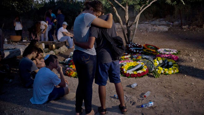 Friends of Shira Banki, a teenage girl stabbed by anti-gay extremist in Thursday's attack on Jerusalem's gay pride parade, mourn by her grave after the funeral in Kibbutz Nachshon, central Israel, pm Monday, Aug. 3, 2015. Banki wounded in the attack died of her wounds Sunday.