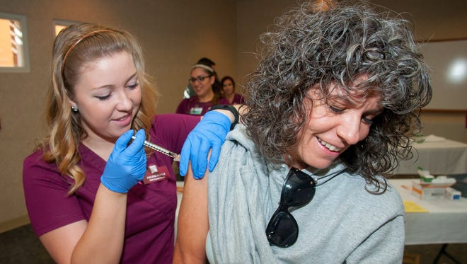 Mary Lujan gets her free flu shot from NMSU student nurse Kailene Ruttle at Memorial Medical Center's yearly flu clinic. Lujan has received a flu shot from the clinic every year since it opened.