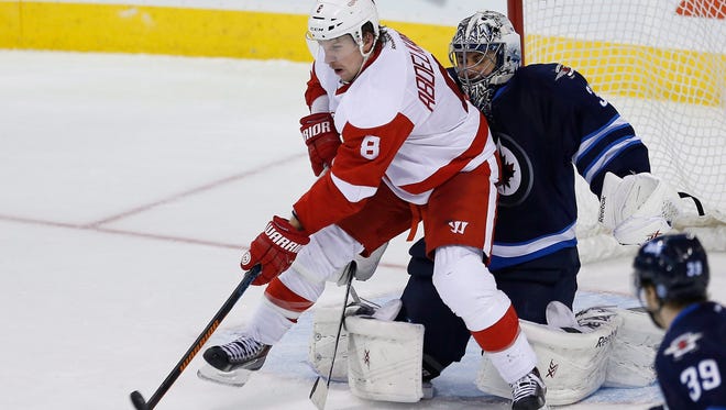 Red Wings forward Justin Abdelkader (8) deflects the puck past Jets goaltender Ondrej Pavelec for the tying goal.