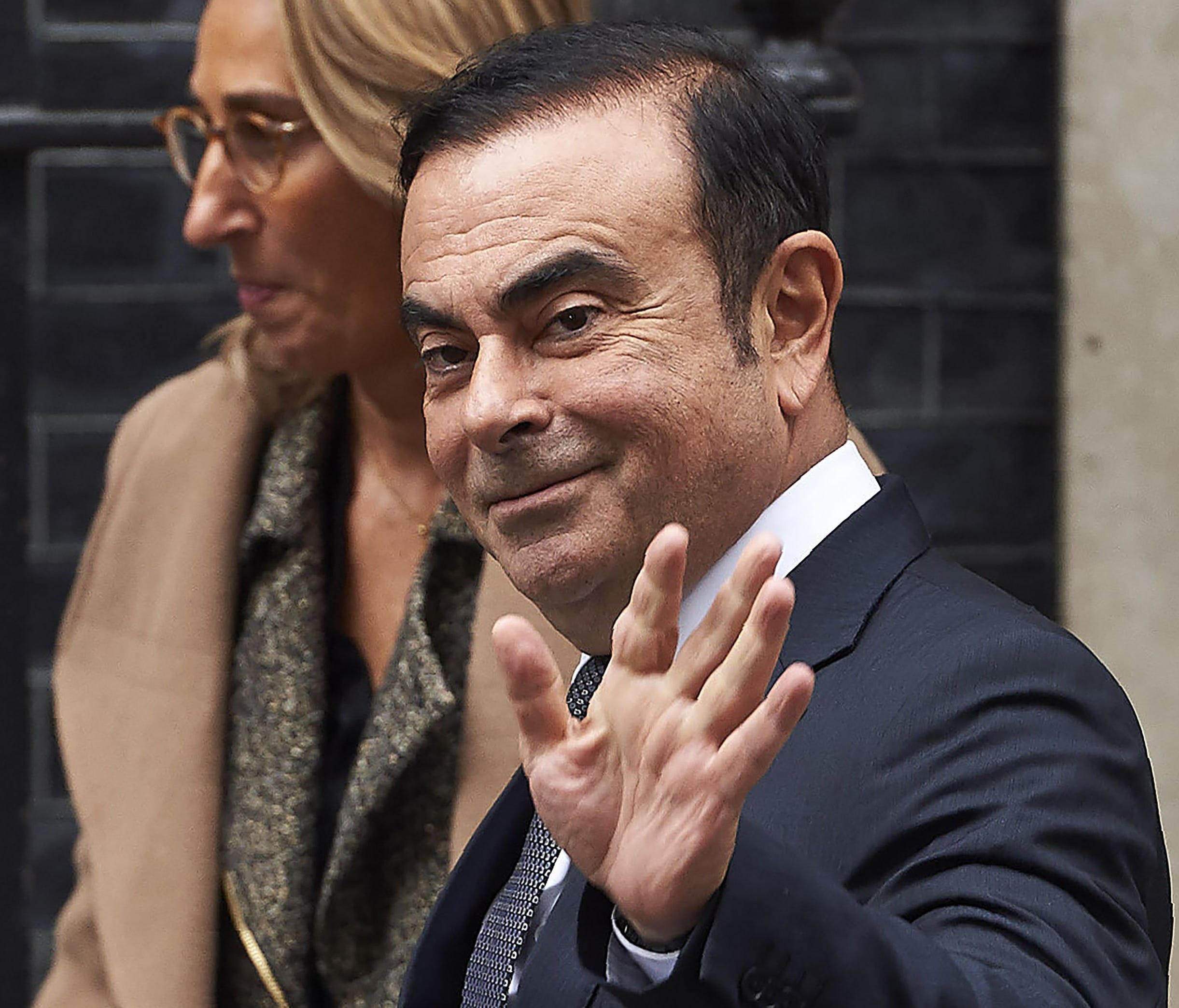Nissan CEO Carlos Ghosn waves as he leaves No. 10 Downing St. in central London