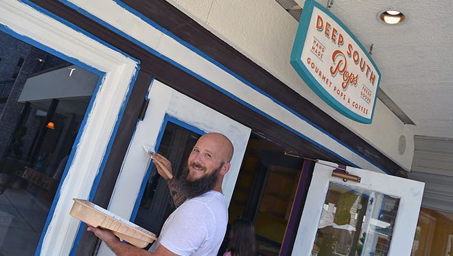 Deep South Pops owner and operator Jake Franklin paints the outside of the second Deep South Pops handmade popsicles and coffee location, opening soon in Highland Village in Jackson.