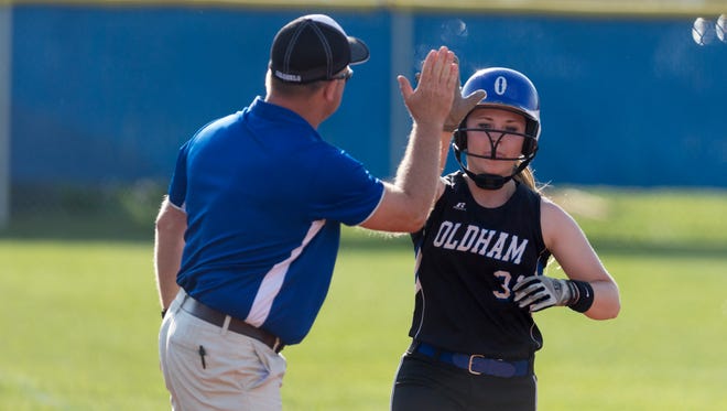 Oldham County's Taylor Sheller gives the base coach a high five on her way towards home plate during the high school softball game between the Ballard Bruins and the Oldham County Colonels.