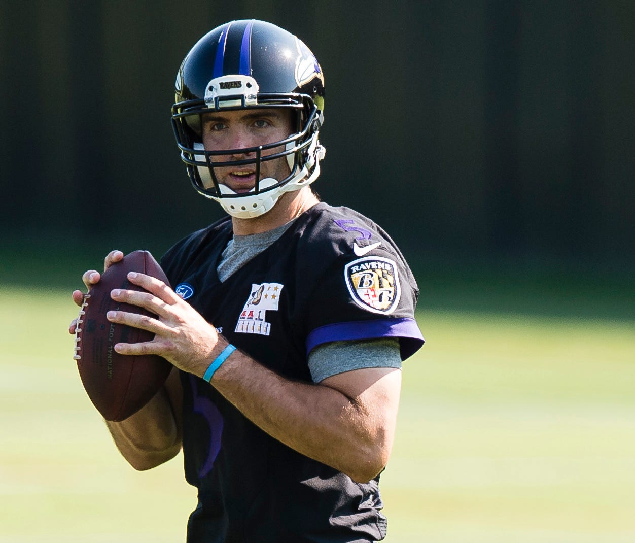 Baltimore Ravens quarterback Joe Flacco (5) drops back to throw a pass during the first day of minicamp at Under Armour Performance Center.