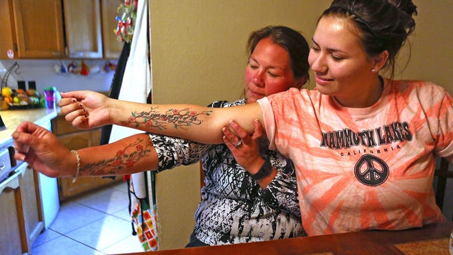 Gracie Jordan, right, and mother Dawn Jordan show off their tattoos. Gracie’s reads “You gave me the gift of life” and Dawn's reads “But life gave me the gift of you.” Dawn adopted Gracie after her biological mother wounded her badly and killed her little sister in 2002.