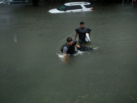 People walk through flooded streets during the aftermath