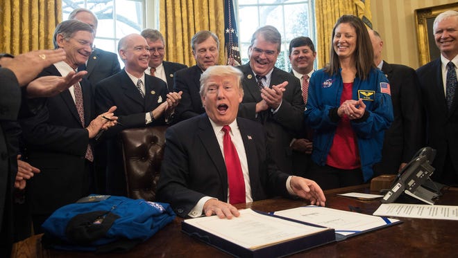 President Donald Trump reacts after signing a bill increasing funding for NASA in the Oval Office at the White House in March.
