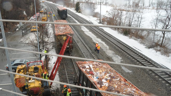 Workers from the R.J. Corman Railroad Group and Metro-North tend to the derailed train car, located underneath the overpass off of Beekman Street and within sight of the Beacon train station on the Hudson Line.