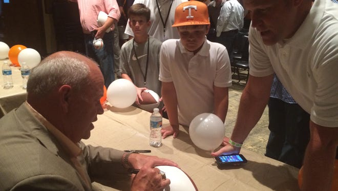 Former Tennessee coach Phillip Fulmer signs a football for a fan Saturday in Milan.
