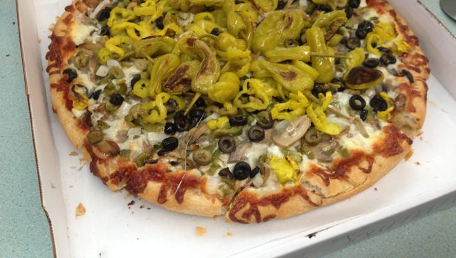 This veggie pizza has black and green olives, onions, mushrooms and loads of peppers.