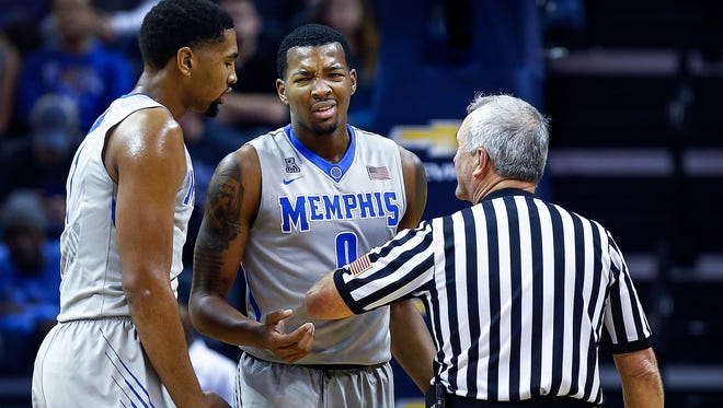 University of Memphis forward K.J. Lawson (middle) is not happy with an official's foul call on him during the first half against McNeese at FedExForum.