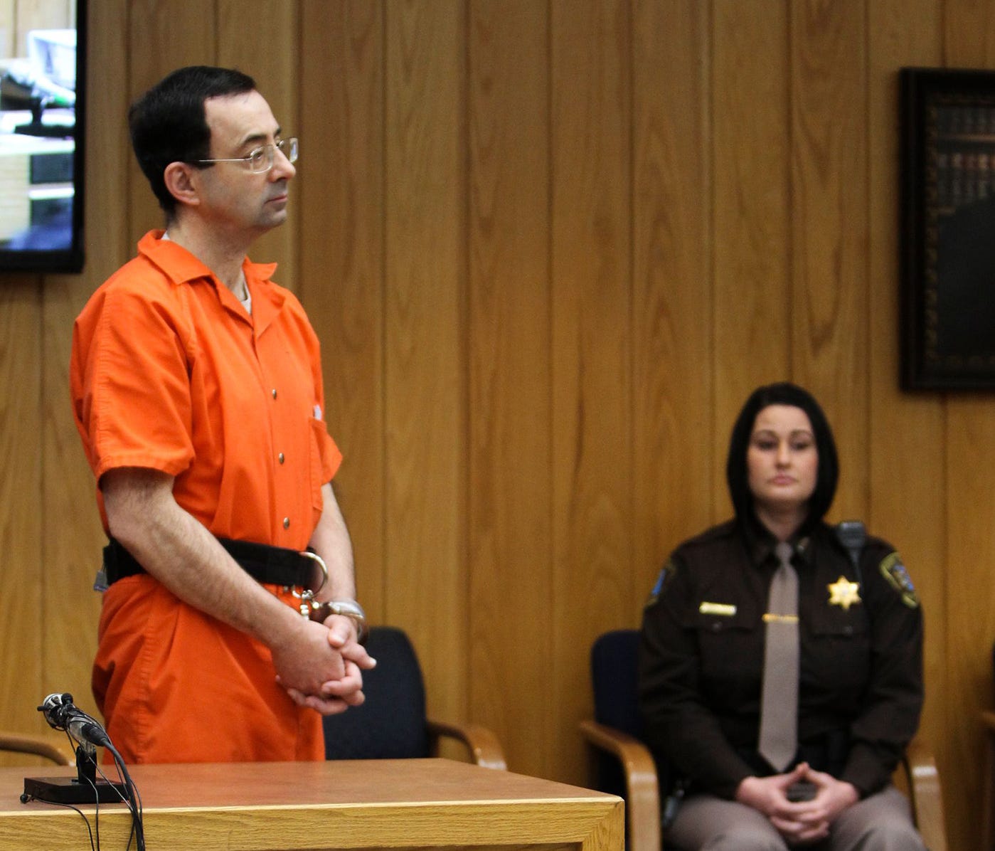 Larry Nassar stands to hear an Eaton County (Mich.) Circuit judge deliver his sentence Monday, Feb. 5, 2018, the third and final day of sentencing in Charlotte, Mich.