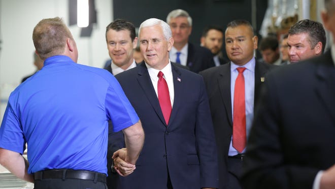United States Vice President Mike Pence, center left, meets an unidentified employee during a tour of the TKO Graphix facility in Plainfield Ind. on Thursday, Nov. 9, 2017.
