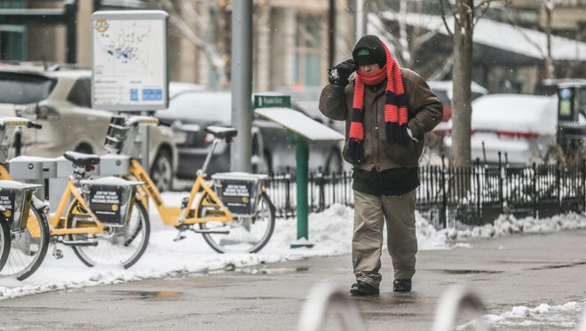 A man bundles up for the cold while walking in downtown Indianapolis on Monday, Jan. 15, 2018. 