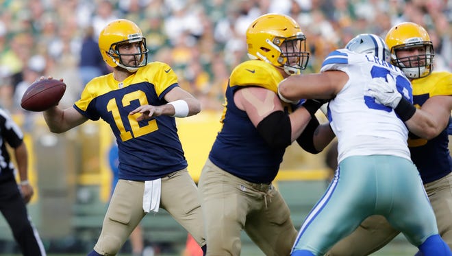 Green Bay Packers quarterback Aaron Rodgers looks to pass against the Dallas Cowboys at Lambeau Field.