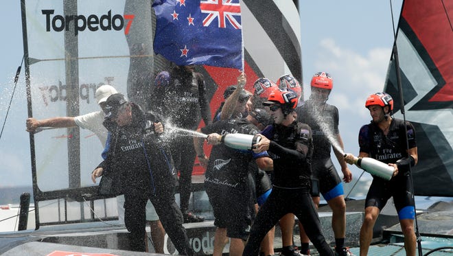 The crew of Emirates Team New Zealand spray champagne as they celebrate after defeating Oracle Team USA to win the America's Cup sailing competition June 26 in Hamilton, Bermuda.