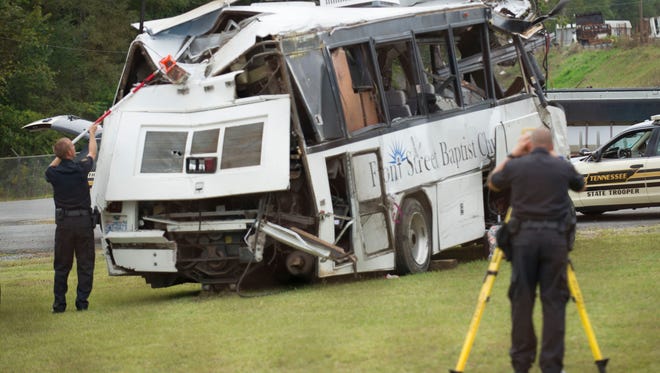 Investigators examine the church bus involved in the fatal Interstate 40 accident on Thursday, Oct. 3, 2013, at a Tennessee Department of Transportation facility in Newport. Authorities suspect a blown tire caused the bus  to cross the median and crash into an SUV and tractor-trailer, killing eight people and injuring 14.  (Paul Efird/News Sentinel)