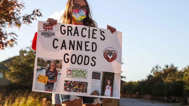Gracie Garbade, 11, holds a sign asking for donations in Cedar Park on Tuesday.