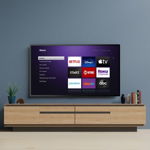 A Roku TV mounted on the wall displaying shortcuts
