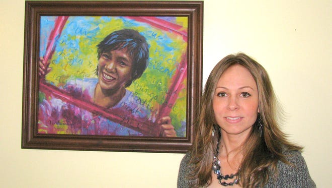Nicole Troup with her portrait of Charmaine, a victim of human trafficking.