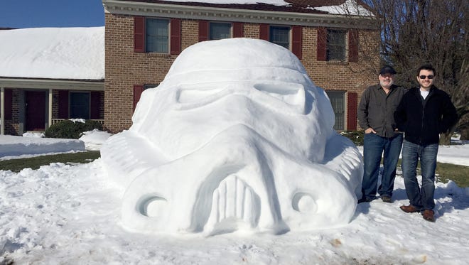 Jim Zimmerman, left, and son, Drew, stand next to their completed stormtrooper snow sculpture.