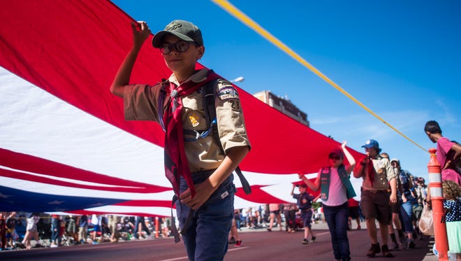 Scout troops carry a giant American flag down 1st Avenue South during the Fourth of July parade downtown.