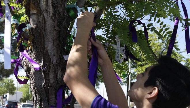 Luis Gomez ties a ribbon to represent the baby he was walking for in this 2015 file photo of the March of Dimes annual March for Babies event.