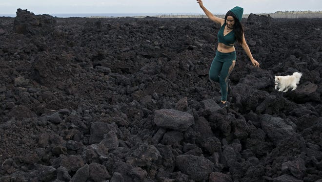 Tisha Montoya and her dog Bebe last month cut through the lava field that destroyed her home near Pahoa, Hawaii.