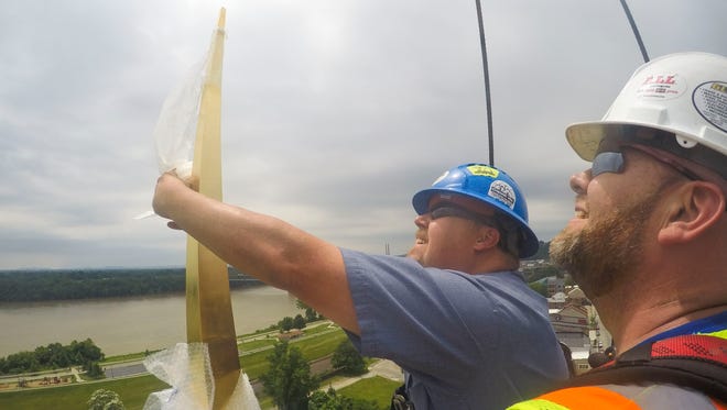 Matt Gay, left, and Bryan Akin of Campbellsville Industries unwrap the gold-colored finial that adorns the new steeple of the Second Baptist Church that was installed Thursday in New Albany. The 65-foot-spire was possible with funds raised by the Friends of the Town Clock group. The original steeple was destroyed by lightening in 1914. The church was part of the Underground Railroad during the Civil War, where slaves could escape to once crossing the Ohio River.