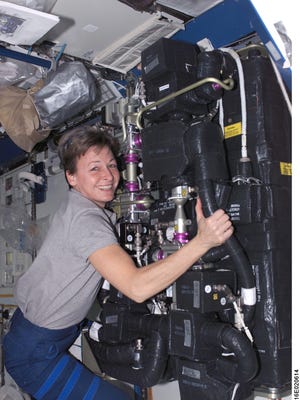 In this undated photo, astronaut Peggy A. Whitson performs maintenance on the carbon-dioxide removal assembly, a Honeywell Aerospace product, during International Space Station Expedition 16.