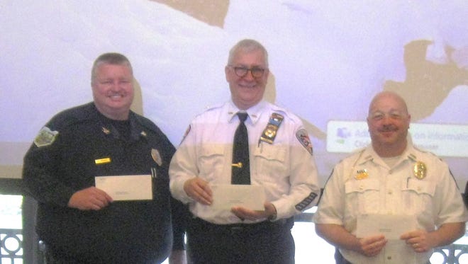 Local law-enforcement officers hold checks for $750 donated by the Sandusky County Safety Council.
