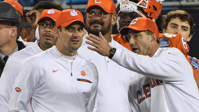 Clemson head coach Dabo Swinney, right, talks with co-offensive coordinators Tony Elliott, left, and Jeff Scott in the closing seconds of a 38-3 in over Miami in the ACC football championship game in Charlotte on December 2, 2017.