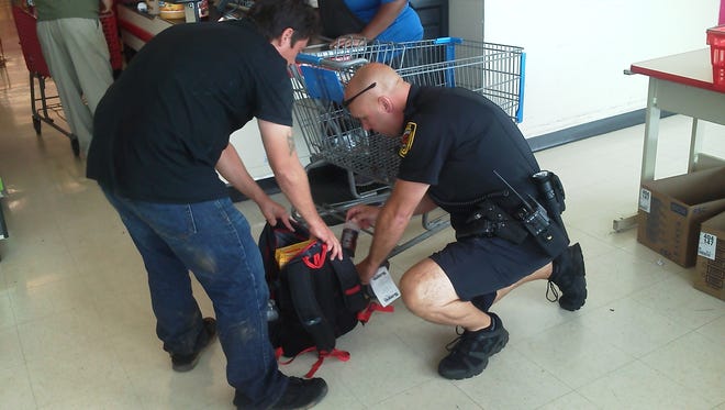 Officer Mark Stevens helps a man pack his backpack with food and water.