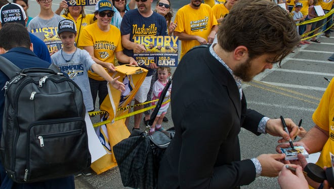 Fans cheers as the Nashville Predators' Pontus Aberg signs a hockey card at the Nashville International Airport in Nashville, Tenn., before the team travels to Pittsburgh for the beginning of the Stanley Cup Final Saturday, May 27, 2017.