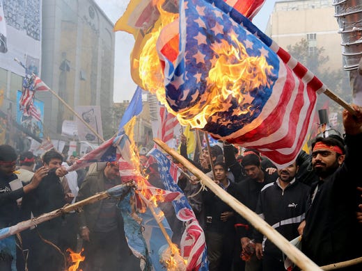 Demonstrators burn U.S. and Israeli flags during a demonstration marking the 34th anniversary of the U.S. Embassy takeover on Nov. 4 in Tehran. Thousands of protesters gathered in front of the former U.S. embassy in Tehran to mark the beginning of the 1979 hostage crisis, burning flags and chanting anti-U.S. slogans.