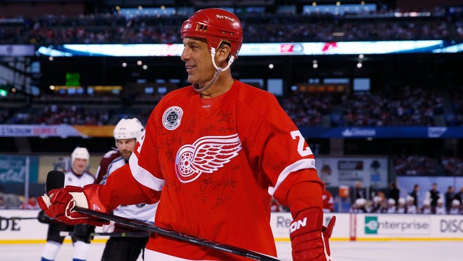 Detroit Red Wings defenseman Chris Chelios wears a sweater signed by teammates against the Colorado Avalanche at Coors Field in Denver on Feb. 26, 2016.