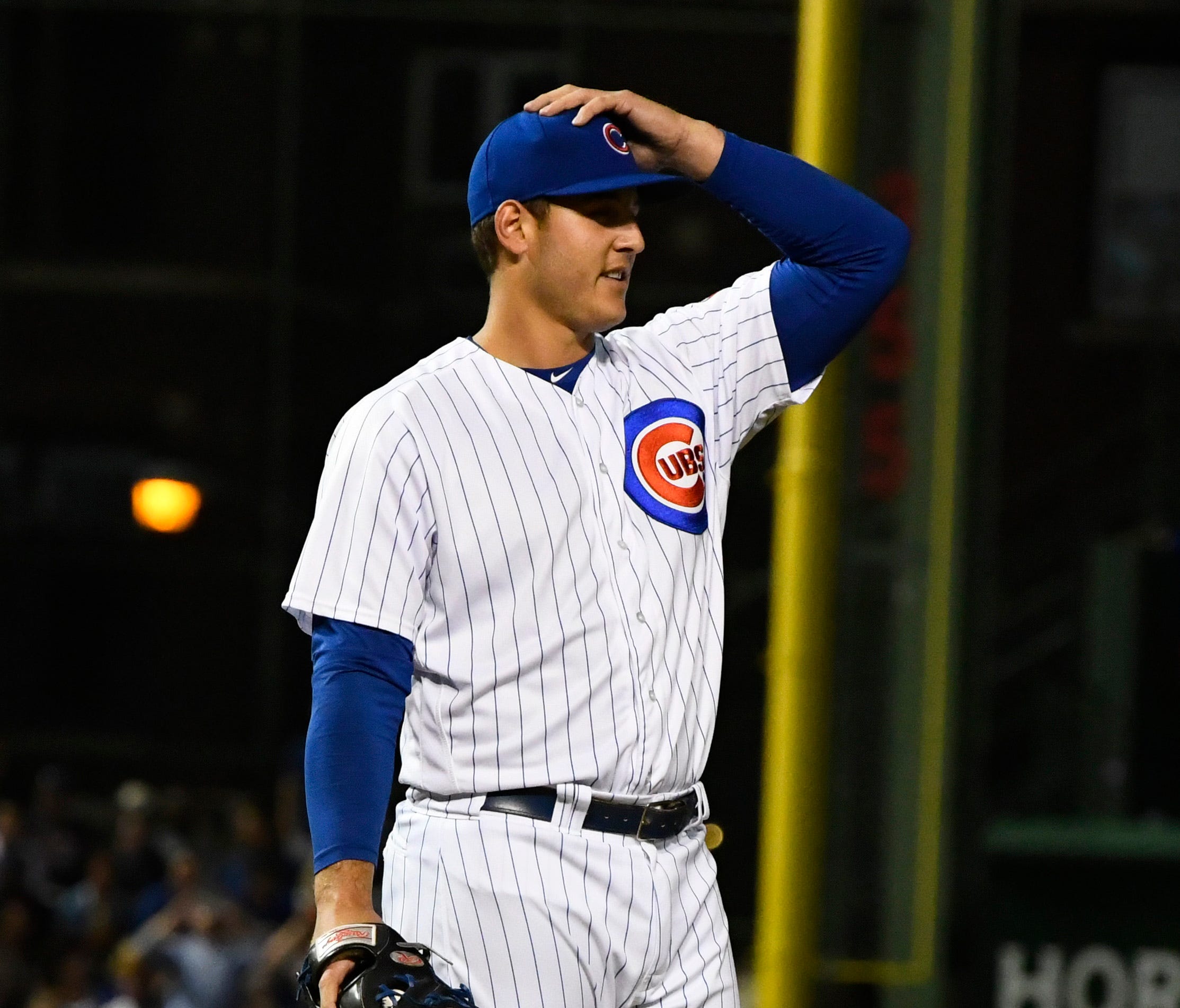 Chicago Cubs first baseman Anthony Rizzo (44) holds his hat while he stands on the mound to pitch against the Arizona Diamondbacks in the ninth inning at Wrigley Field.