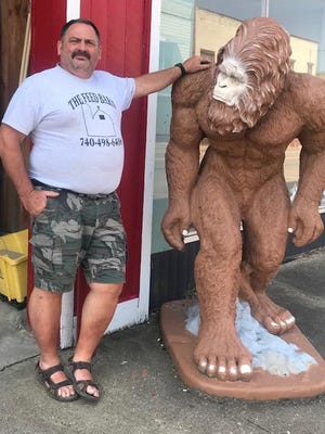 Jeff Eggleston, co owner of The Feed Barn, is pictured with one of the more popular landscaping statues, Bigfoot.  Photo by Kristie Wilkin