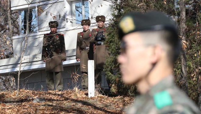 In this Nov. 27, 2017, file photo, North Korean soldiers look at the South side as a South Korean stands guard near the spot where a North Korean soldier crossed the border on Nov. 13 at the Panmunjom, in the Demilitarized Zone, South Korea.