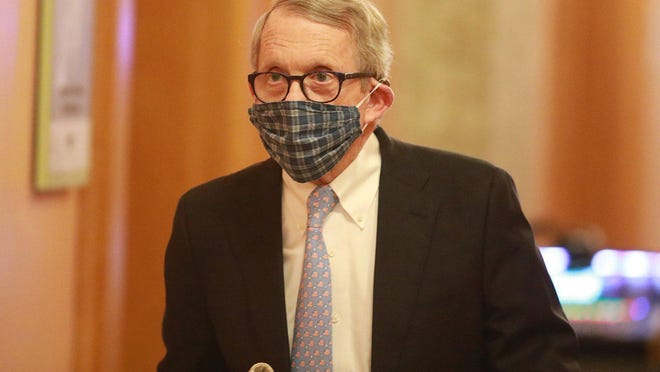 Wearing his protective mask made by his wife, Ohio Gov. Mike DeWine walks into his daily coronavirus news conference on Thursday, April 16, at the Ohio Statehouse in Columbus.