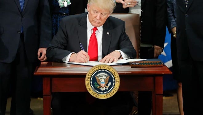 President Donald Trump signs an executive order for border security and immigration enforcement improvements at the Department of Homeland Security in Washington, D.C.