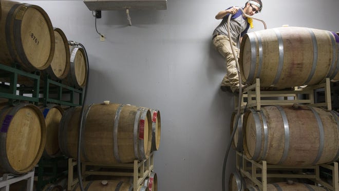 Christopher Whitehorn, who is in the vintner program at Yavapai College, is working at Javelina Leap Vineyard & Winery in Page Springs. Here, he emptying wine barrels.